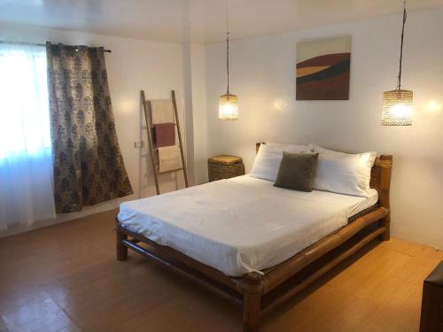 1 dormitorio con 1 cama con sábanas y almohadas blancas en Balai Roco en Bauang