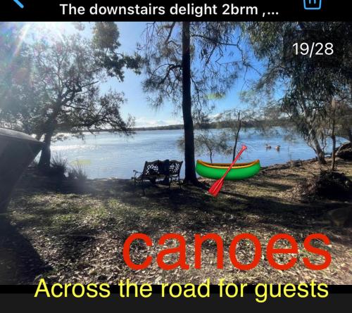 a canoe and a bench next to a lake at The downstairs delight 2brm , 6+ guests & dogs ok in Lake Munmorah