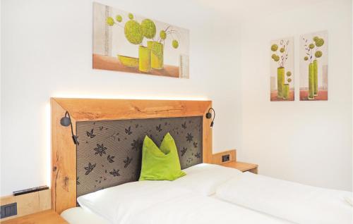 un letto con testiera in legno e cuscino verde di 2 Bedroom Cozy Apartment In Flachau a Flachau