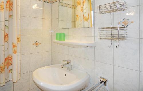 La salle de bains blanche est pourvue d'un lavabo et d'un miroir. dans l'établissement 2 Bedroom Cozy Apartment In Flachau, à Flachau