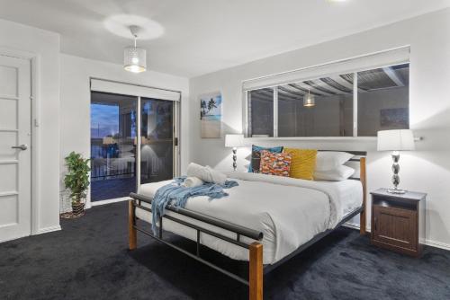 1 dormitorio con cama y ventana en HAZE18 - Sunny Shorefront Retreat Uninterrupted Ocean Views, en Quinns Rocks