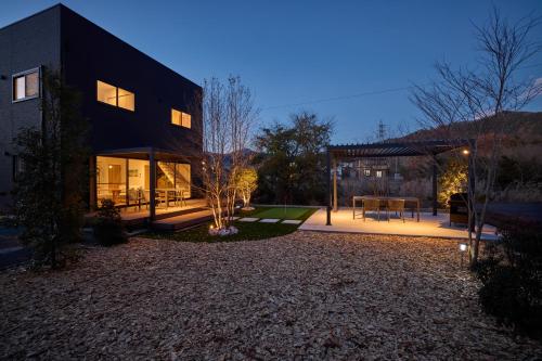 a large black house with a courtyard in front of it at 富士ガーデンビュー　空と庭と in Fujikawaguchiko