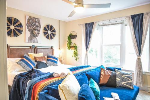 a bedroom with a bed and a blue couch at Chic 4BR Dwelling with Backyard in Philadelphia in Philadelphia