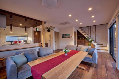 a living room with a table and blue chairs at 富士ガーデンビュー　空と庭と in Fujikawaguchiko