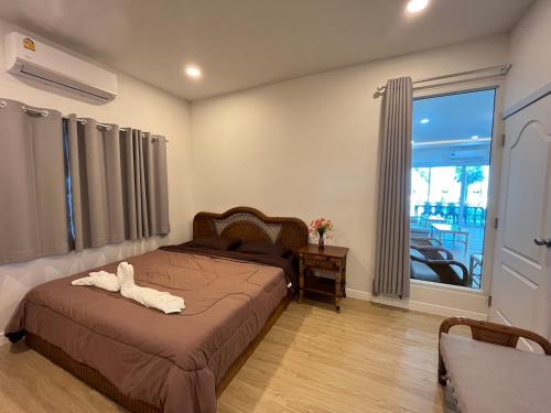 a bedroom with a bed with a white animal on it at หาดช้างเผือกเจ้าสำราญ Chang Phueak Chao Samran Beach in Haad Chao Samran