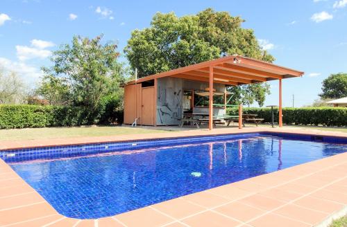 a swimming pool with a pavilion next to a house at The Gidgee Inn in Cloncurry