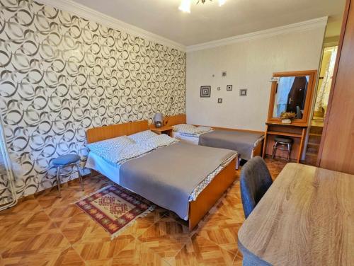 a bedroom with two beds and a table in it at Paata's Guesthouse in Borjomi