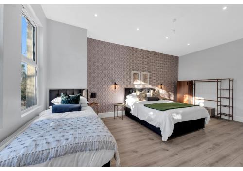 1 Schlafzimmer mit 2 Betten und einem großen Fenster in der Unterkunft Astonishing 4BR House - Perfect for a Big Family in Southend-on-Sea