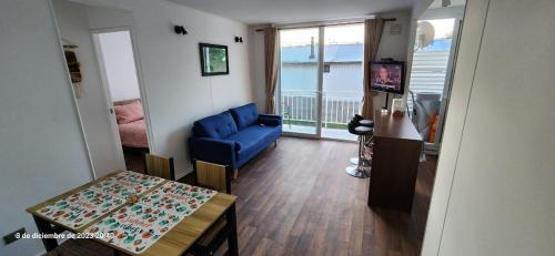 un soggiorno con un divano blu e un tavolo di Departamento en Pucón a Pucón