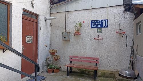 a red bench sitting in front of a building at Paata's Guesthouse in Borjomi