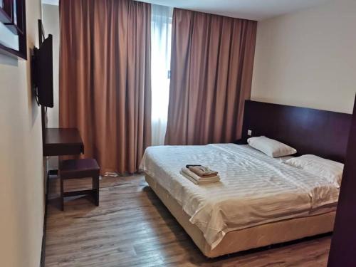 a bedroom with a bed and a desk and a window at LUCKY - 5 INN in Bintulu