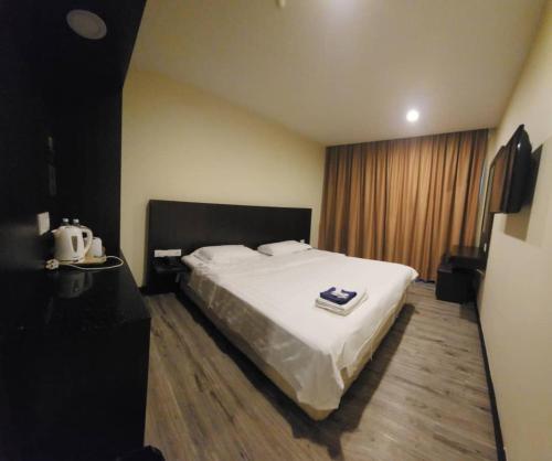 um quarto com uma grande cama branca num quarto em LUCKY - 5 INN em Bintulu