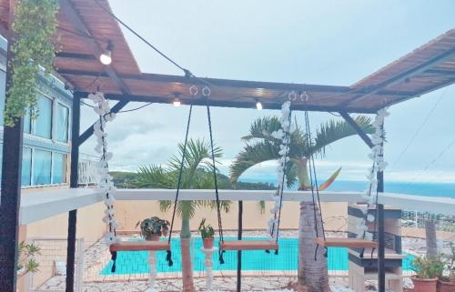 a porch swing with a view of a pool at Lilie location sud in Petite Île
