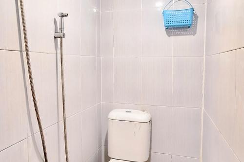 a white tiled bathroom with a toilet and a shower at Handira Homestay Syariah Padang RedPartner in Duku