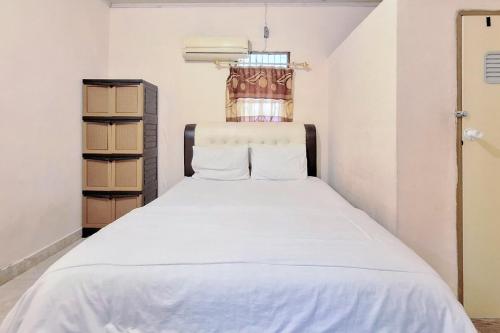 a bedroom with a white bed in a room at Handira Homestay Syariah Padang RedPartner in Duku