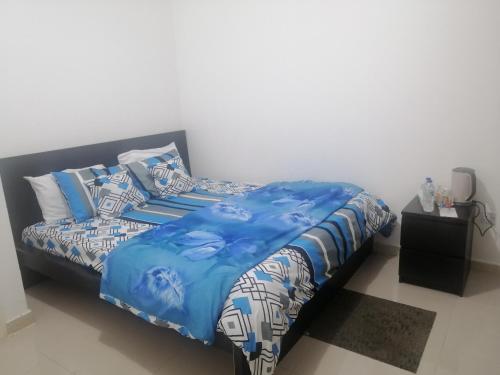 a bed with blue and white sheets and pillows at ETAS Residence in Abu Dhabi