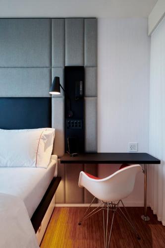 a bedroom with a bed and a desk and a chair at citizenM Menlo Park in Menlo Park