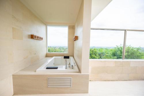 a bathroom with a sink and a large window at Taman Prakerti Bhuana Hotel in Gianyar