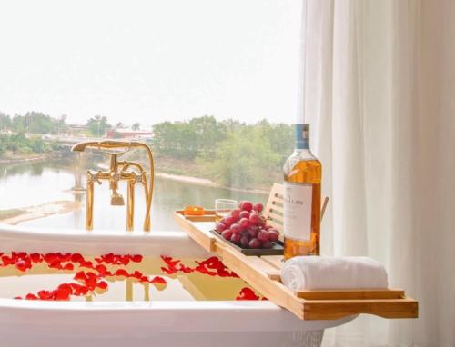 Sóc Sơn的住宿－Lake Hotel Sóc Sơn，浴室水槽,配有一瓶葡萄酒和葡萄