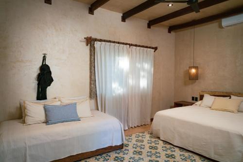 um quarto com 2 camas e uma janela em Mero Mero Hotel em El Cuyo