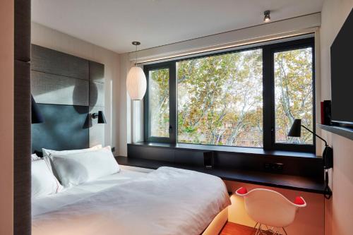 1 dormitorio con cama y ventana grande en citizenM Rome Isola Tiberina, en Roma