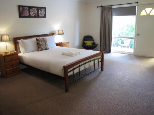 a bedroom with a large bed and a sliding glass door at 1839 Cottages in Willunga