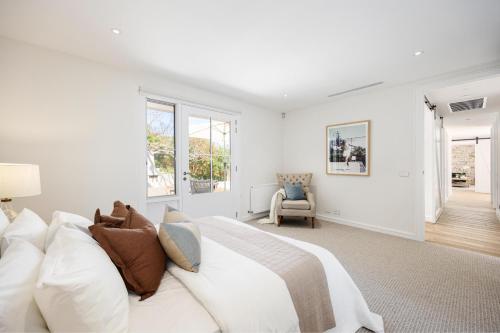 1 dormitorio blanco con 1 cama y 1 silla en Sandhamn – Luxury Sorrento Accommodation, en Sorrento