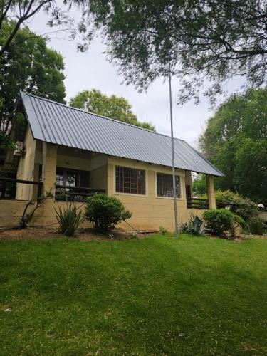 a small yellow house with a metal roof at Riverside Lodge & Conference Center in Aliwal North