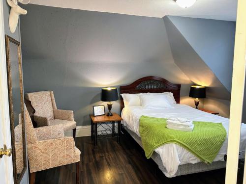 a bedroom with a bed with a green blanket and a chair at Historic 2 bedroom house St Charles in St. Charles