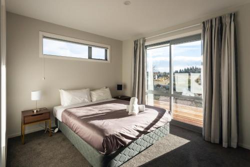 1 dormitorio con cama y ventana grande en Josephine's Lakeside Star, en Lake Tekapo