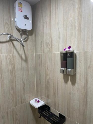 a bathroom with a toilet with a hair dryer on the wall at My Home in Patong Beach