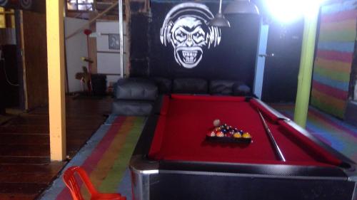 una mesa de billar en una habitación con una cara de payaso en la pared en Crazy Monkey en Trat
