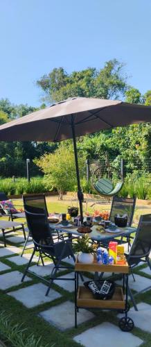南圣弗朗西斯科TALI HOUSE - Casa Hotel的露台上的一张桌子、几把椅子和一把遮阳伞