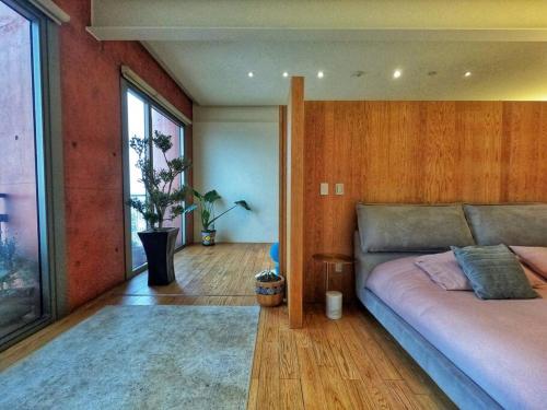 メキシコシティにあるThe most epic flat in town!のベッドと大きな窓のある寝室