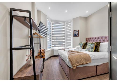 1 dormitorio con cama y ventana grande en Escape the Ordinary: Cozy and Charming Studio, en Londres
