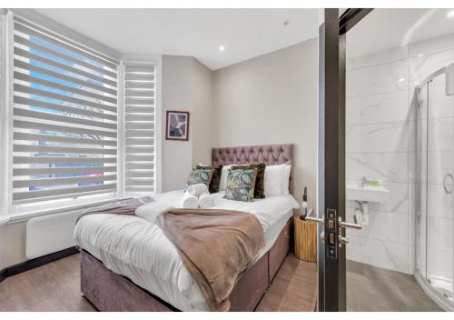 1 dormitorio con cama grande y ducha en Escape the Ordinary: Cozy and Charming Studio, en Londres