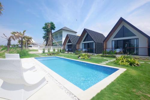a villa with a swimming pool in front of a house at Padi Villas by Aayan in Canggu