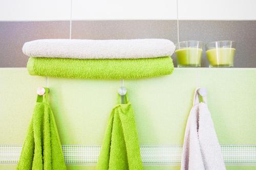 a towel rack with green towels and two glasses of orange juice at Apartment Zelená zahrada in Mladá Vožice