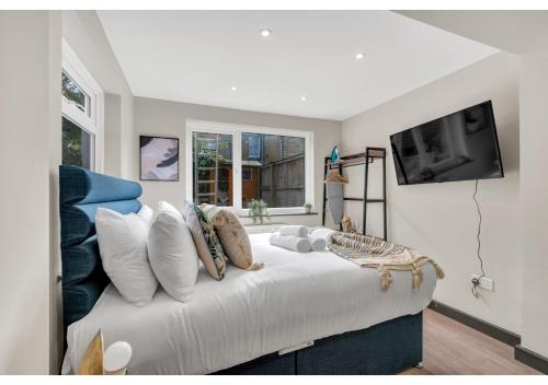 1 dormitorio con 1 cama blanca grande con almohadas en The Ultimate Hangout Spot: Modern Studio en Londres