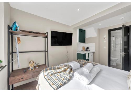 1 dormitorio con 1 cama blanca y TV en The Ultimate Hangout Spot: Modern Studio en Londres