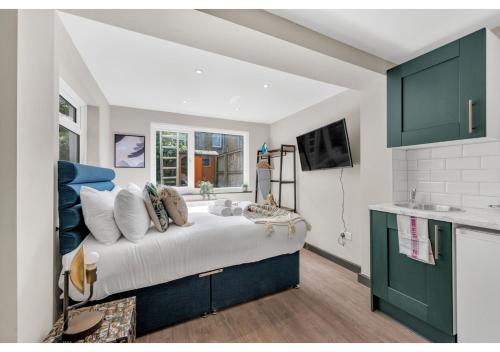 1 dormitorio con 1 cama grande con almohadas en The Ultimate Hangout Spot: Modern Studio en Londres