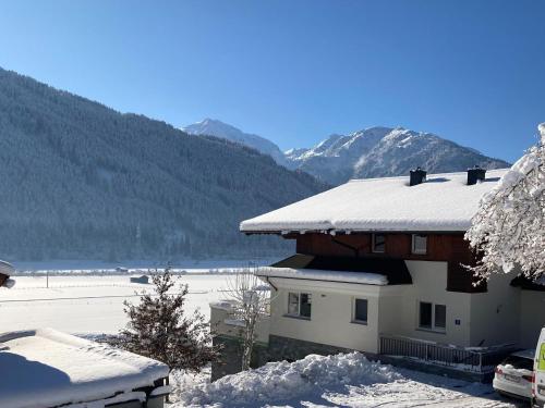 a house covered in snow with mountains in the background at Chalet in Mittersill near Ski Lift in Mittersill