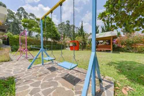 a swing set in a yard with a playground at RedDoorz At Pondok Winagung Ciwidey in Ciwidey