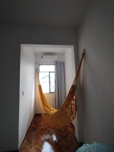 a hammock in a room with a window at charmoso vista mar apê copa 80 metros da praia in Rio de Janeiro
