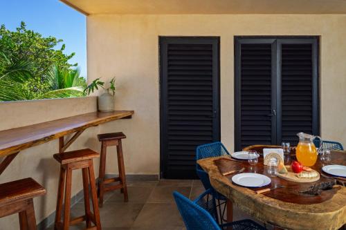 a table with chairs and a table with food on it at Mero Mero Hotel in El Cuyo