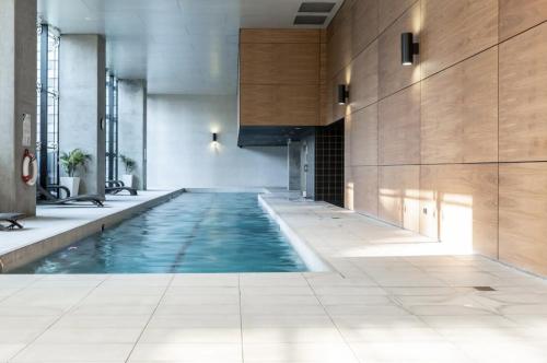 a swimming pool in a building with a tile floor at City Lights & Manhattan Heights - A Gem in Melbourne in Melbourne
