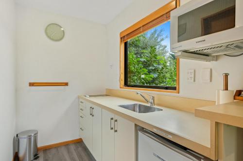a kitchen with a sink and a window at Alpine Garden Motel in Hanmer Springs