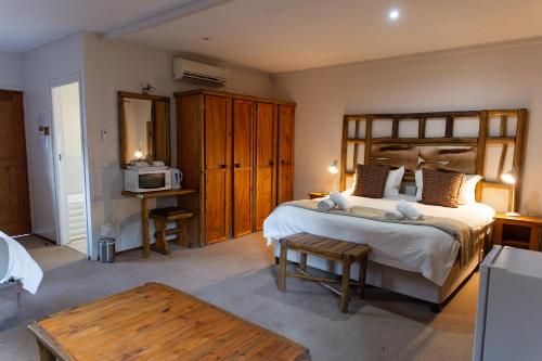 a bedroom with a large bed and a microwave at Riverside Lodge & Conference Center in Aliwal North