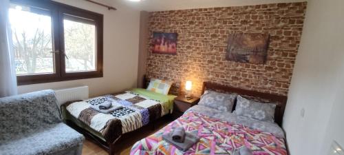 a bedroom with two beds and a brick wall at Country House on Mount Olympus in Kariá