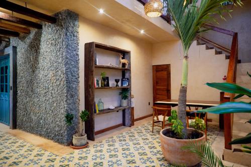 a living room with a palm tree and a table at Mero Mero Hotel in El Cuyo